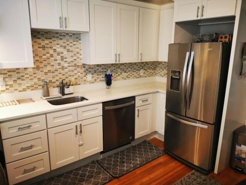 波士顿Location+Comfort+Convenience的厨房配有白色橱柜和不锈钢冰箱