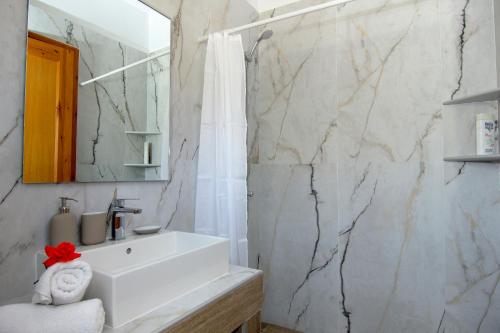 圣尼古拉奥斯Alkyoni Apartments的浴室配有白色水槽和大理石墙