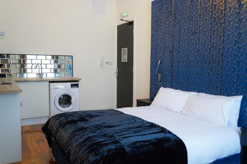 格拉斯哥S.H Apartments的一间卧室配有一张床和一台洗衣机