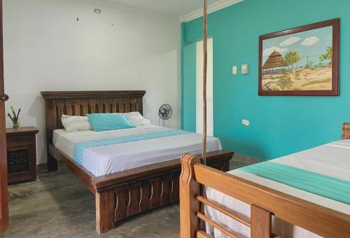 DibullaCoccoloba Beach Hostel的一间卧室设有两张床和蓝色的墙壁