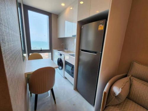 乔木提恩海滩Copacabana jomtien condominium的带冰箱和桌椅的小厨房