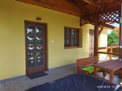 KisnánaHoliday home in Kisnana - Ostungarn 44896的门廊设有木门、桌子和长凳