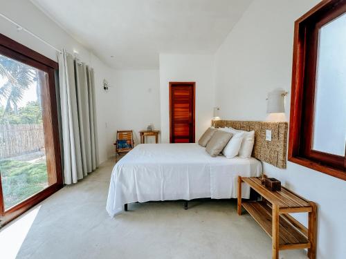 路易斯科雷亚Vila Caiada Guest House的卧室设有白色的床和大窗户