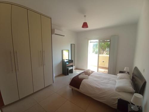 Paphos2 Bedroom Maisonette Mandria Paphos Cyprus的一间卧室设有一张大床和一个窗户。