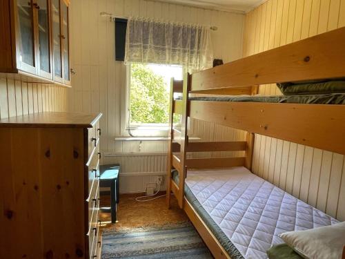 NösundHoliday home Nösund IX的客房设有两张双层床和一扇窗户。