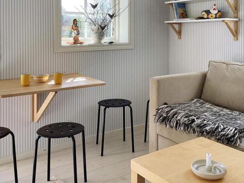 法尔雪平Holiday home FALKÖPING II的客厅配有沙发、桌子和凳子
