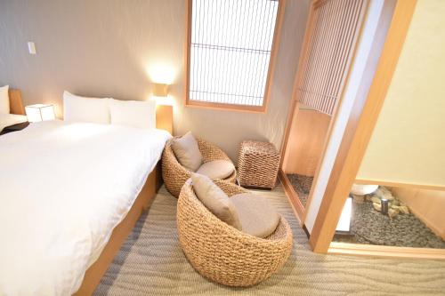 ShimmachidōriK-style Higashihonganji的酒店客房,配有一张床和两把椅子