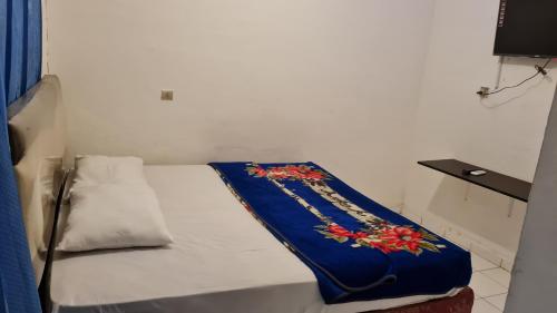 棉兰Acirasa Homestay Medan的一张小床,上面有蓝色的毯子