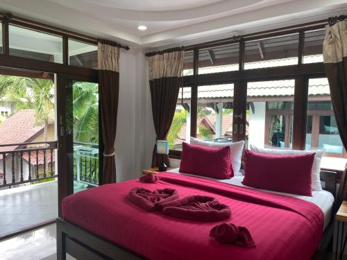 哈德姚Amara Beach Resort Koh Phangan的一间卧室配有一张带红色床单的大床和大窗户