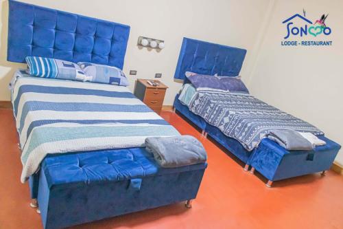 QuillabambaSONCCO LODGE-RESTAURANT的两张睡床彼此相邻,位于一个房间里