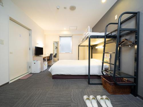 东京Super Hotel Tokyo Kameido的一间卧室配有双层床和书桌
