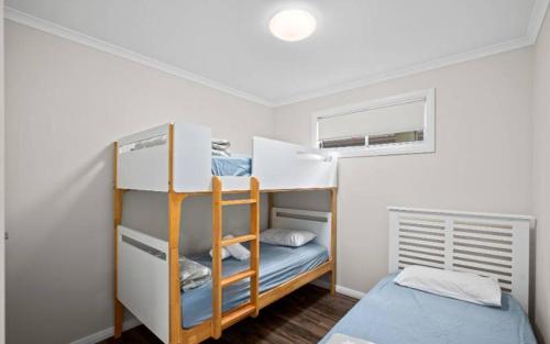 科夫斯港蓝宝石海滩假日公园酒店的小房间设有两张双层床和窗户