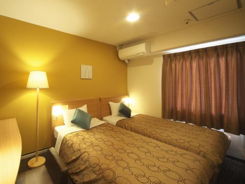 横滨横滨平和广场酒店的酒店客房,设有两张床和一盏灯