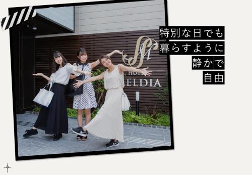大阪Hotel Meldia Osaka Higobashi的一张三位妇女站在一座建筑前面的照片
