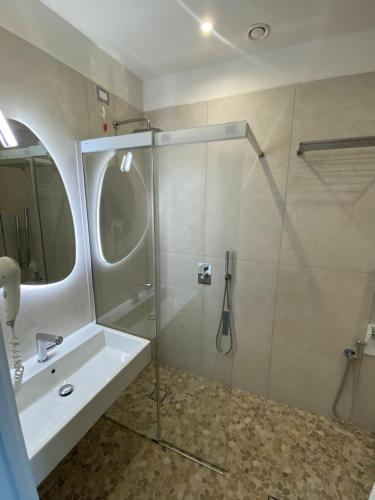 里米尼Hotel Golden的一间带玻璃淋浴和水槽的浴室
