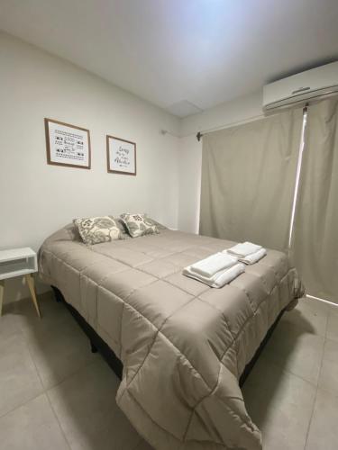 La RinconadaFama Suite YB的一间卧室配有一张大床和两条毛巾
