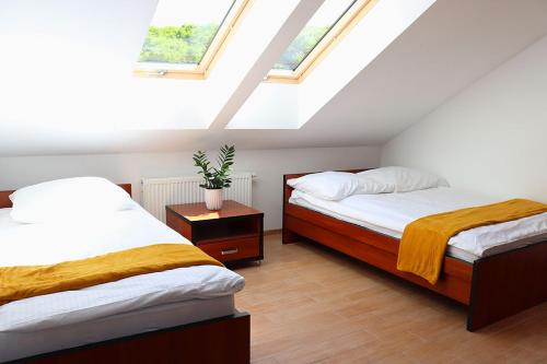 Pokoje gościnne Trzy Młyny的阁楼卧室设有两张床和天窗。