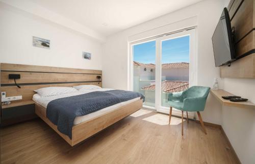 沃迪切Pinia Apartments的一间卧室设有一张床、一个窗口和一把椅子