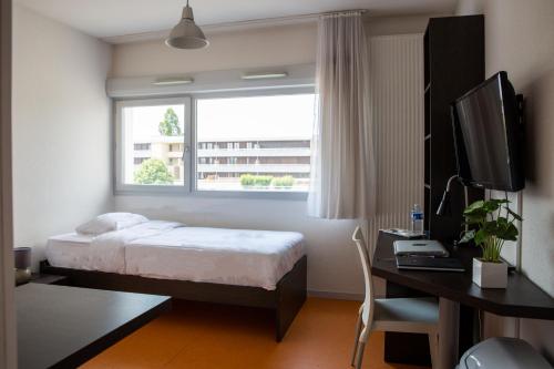 贝桑松勒斯奥特杜沙扎尔禅都公寓式酒店的一间卧室配有一张床、一张书桌和一个窗户。
