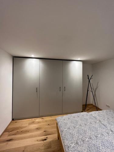 格蒙登Grünberg Apartments的卧室配有白色橱柜和1张床。