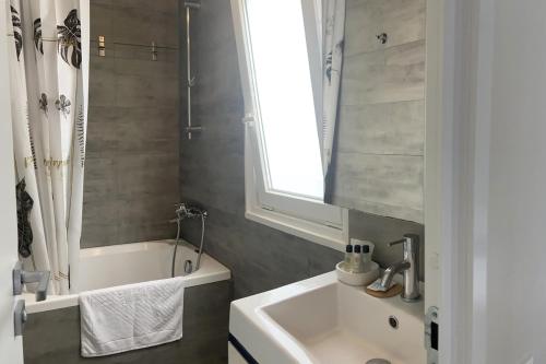 罗维尼Boutique Mobile Homes UlikaRovinj的一间带水槽和浴缸的浴室以及窗户。