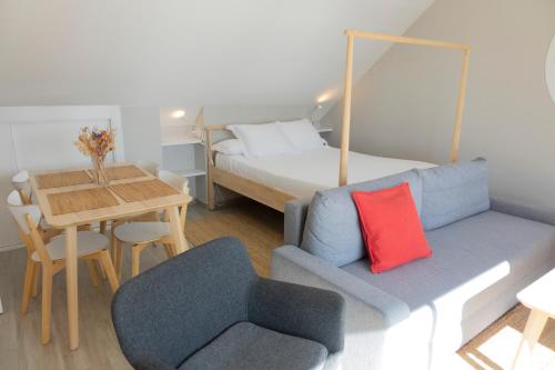 维戈Apartamentos Dunas de Samil的带沙发、床和桌子的客房