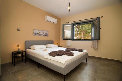 米尔泰Marialenas House - Stone House at Myrties Beach Kalymnos的一间卧室设有一张床和一个窗口