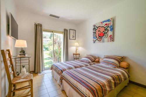 圣特罗佩Villa Alizée B&B的一间卧室设有两张床和窗户。