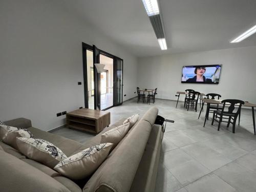加利波利MACHIAVELLI HOUSE的客厅配有沙发和墙上的电视