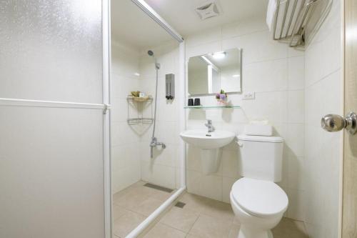 宜兰市乘風之旅溫馨包層華廈每日只接待一組客人最多6人的白色的浴室设有卫生间和淋浴。