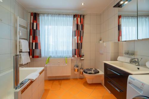 圣卡尼兹enJoy Appartements的带浴缸、卫生间和盥洗盆的浴室