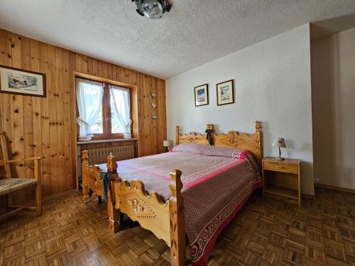 托尔诺Appartamento panoramico La Chapelle的一间带一张大床的卧室,位于带木墙的房间