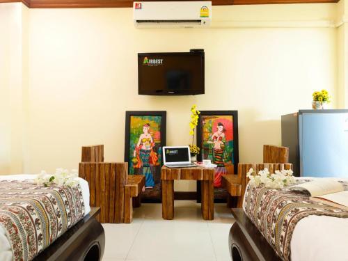 清莱AIRBEST Explore Chiang Rai Hotel的客房设有两张床和一张桌子上的笔记本电脑