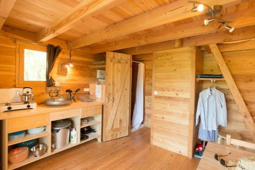阿尔比Huttopia Pays de Cordes sur Ciel的小木屋内的厨房设有木墙