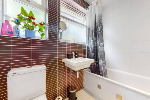 ColindaleModernistic 2 BR maisonette in Kingsbury的一间带水槽和卫生间的浴室以及窗户。
