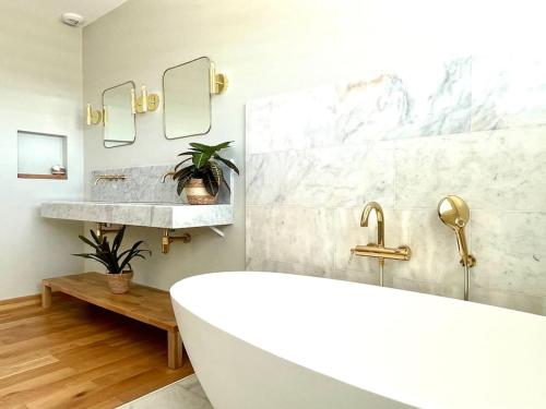 拉格朗德默特La Villa Bord de Mer N02的带浴缸、水槽和镜子的浴室