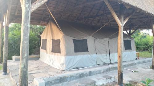 KatunguruEngiri Game Lodge and Campsite的木屋顶下的帐篷
