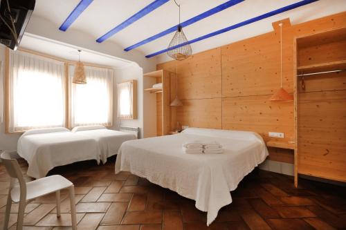 滨海圣波尔B&B Sant Pol - Adults Only的配有木墙和蓝色横梁的客房内的两张床