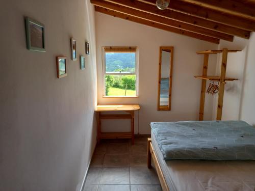 波尔图镇Cosy Private Cottage w/sea views & wifi的一间卧室设有一张床和一个窗口