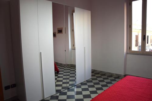 雷焦卡拉布里亚LYDOY APARTMENT的一条空的走廊,有红色地毯和窗户