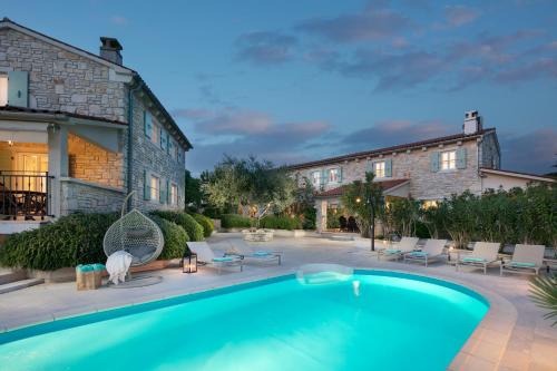 BurićiResidence Pietre d'Istria - with private service的一座带椅子的庭院和一座建筑中的游泳池