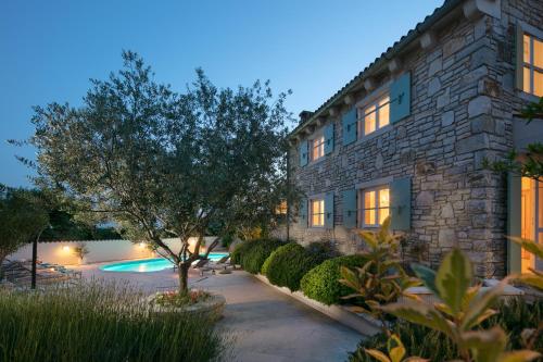 BurićiResidence Pietre d'Istria - with private service的一座有树和游泳池的建筑