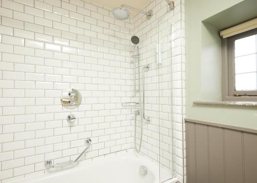 班伯里Red Lion Hotel by Greene King Inns的浴室内设有一个白色瓷砖淋浴和浴缸