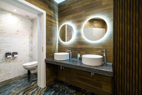 鲁塞比斯特拉加林娜酒店的一间带两个盥洗盆、卫生间和镜子的浴室
