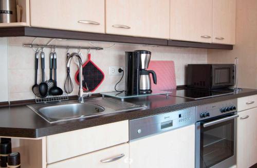 奥茨塞巴德·迪尔哈根SEESTERN App Nr 12 max 6 Pers的厨房配有水槽和炉灶 顶部烤箱