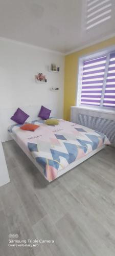 卡拉甘达Яркая квартира в стиле Поп Арт в центре города Караганда的一间卧室配有一张带五颜六色棉被的床