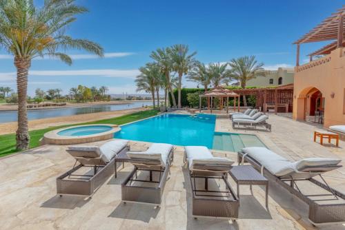 赫尔格达6BR Villa in North Golf El Gouna Private Pool Lagoon Guest house的一座别墅,设有游泳池和棕榈树