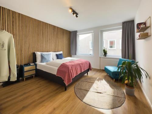 纽伦堡Lorenz Apartments的配有一张床和一把椅子的酒店客房
