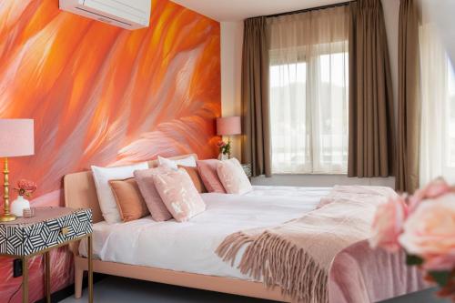 法尔肯堡Dormio Wijnhotel Valkenburg的一间卧室设有一张大床和色彩缤纷的墙壁