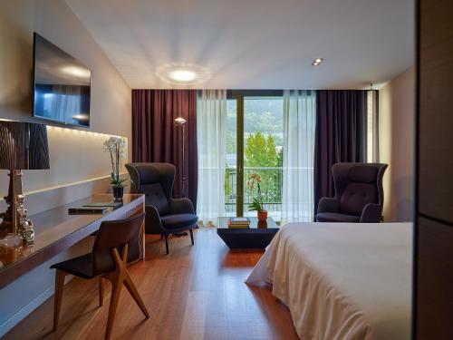 安道尔城安道​​尔公园酒店的酒店客房,配有一张床和两把椅子